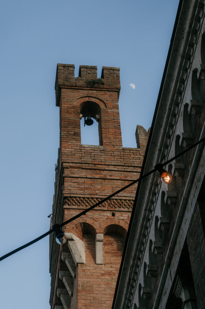 Über den Köpfen der Gesellschaft im Innenhof sieht man einen historischen Glockenturm.