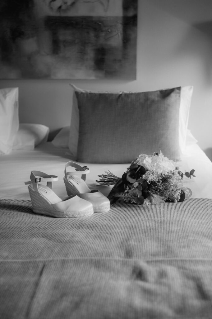 Auf dem Bett liegen der Brautstrauß und die Brautschuhe bereit.