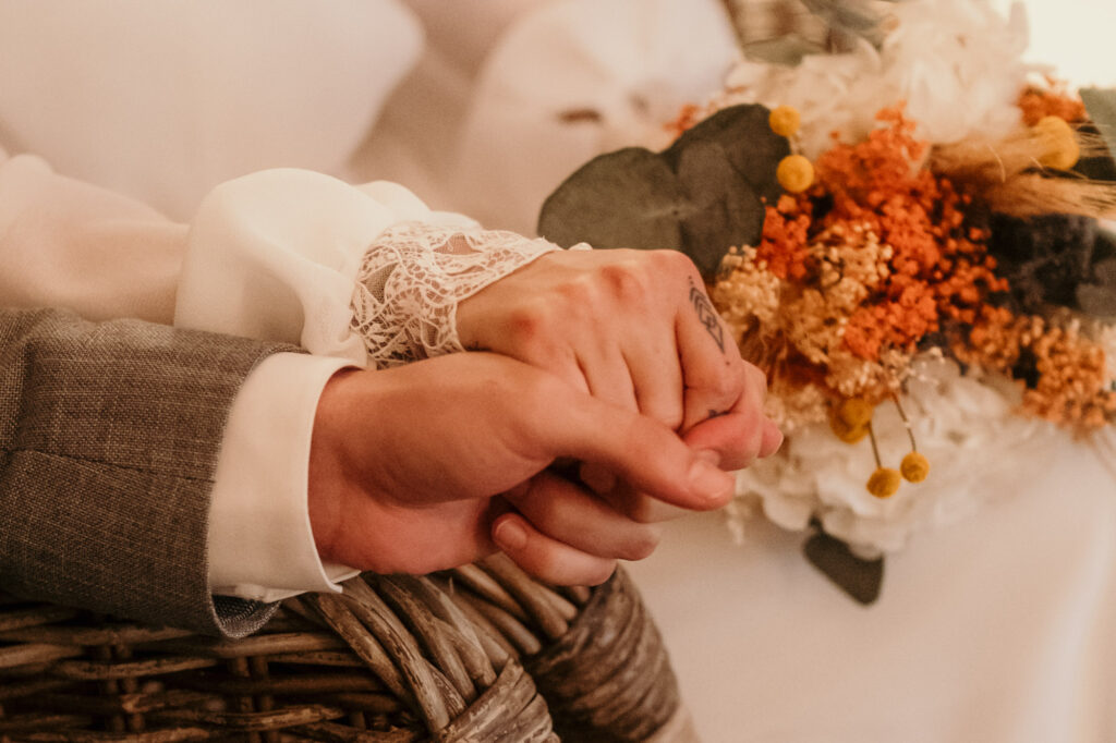 Während der Zeremonie hält das Paar sich fest an der Hand.