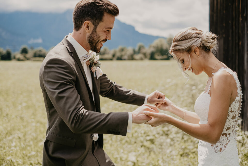 Der First Look sorgt beim Hochzeitspaar für euphorische Emotionen, während sie ihre Hände halten.