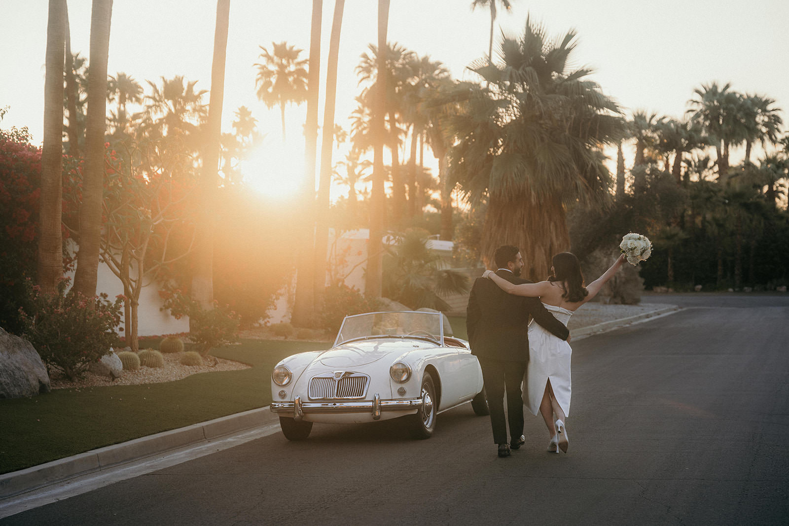 A couple walking down the street on their wedding day to their retro car in Palm Springs.
