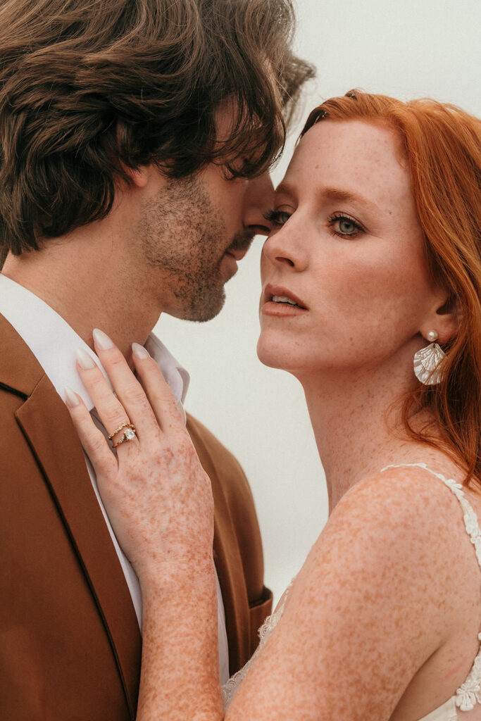 A close up of a couple with the woman looking towards the camera and the men looking away.