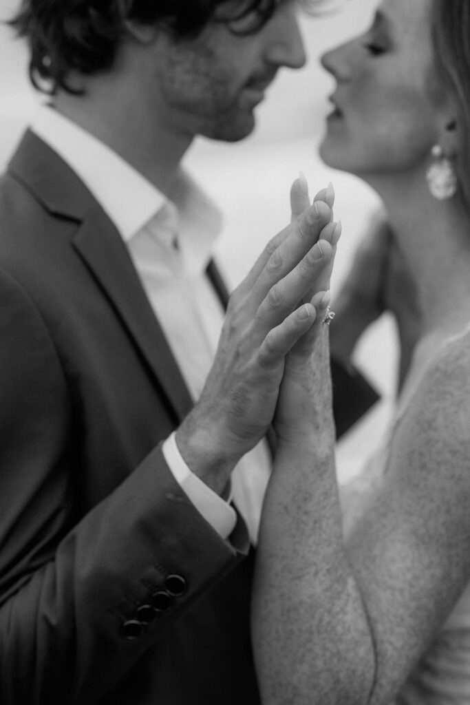 A couple out of focus holding their hands closer to the camera.