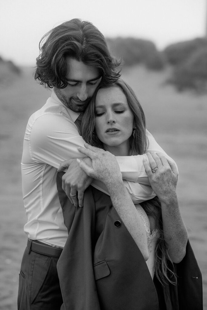 A man hugging his wife from behind.