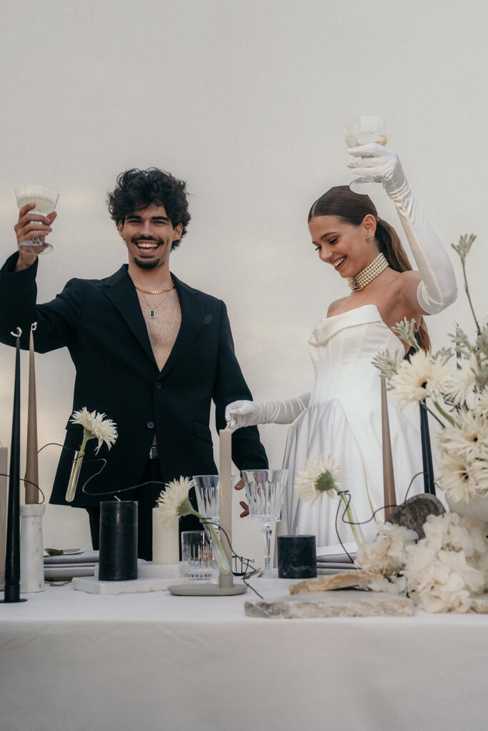 A couple standing up at their reception toasting to their guests.