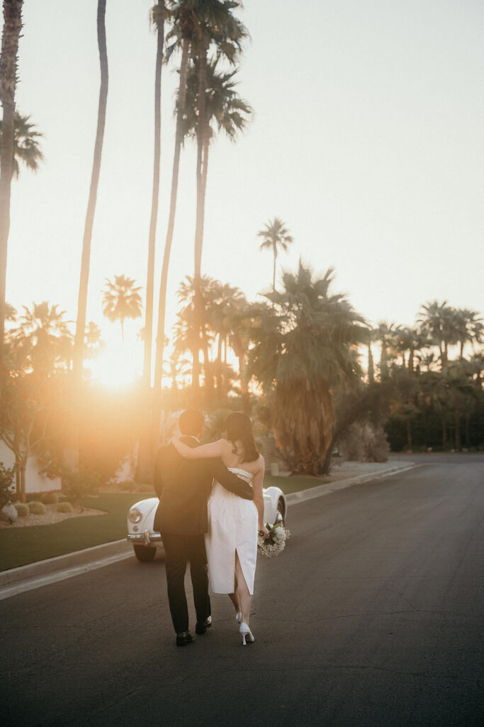 A couple walking away from the camera towards sunrise